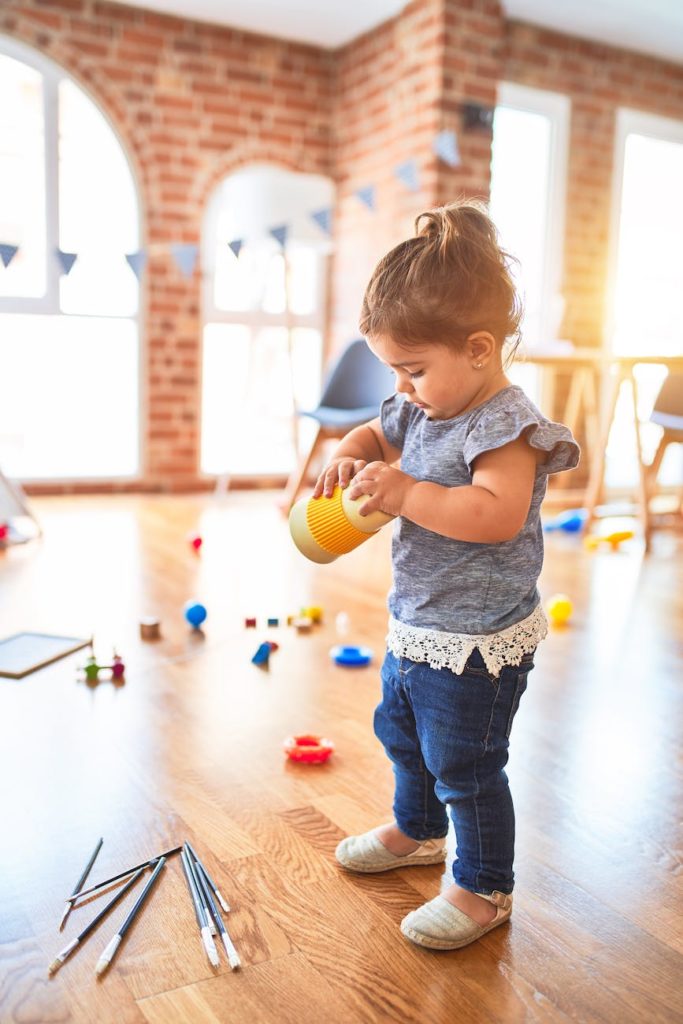 little girl playing with toys inside a playroom